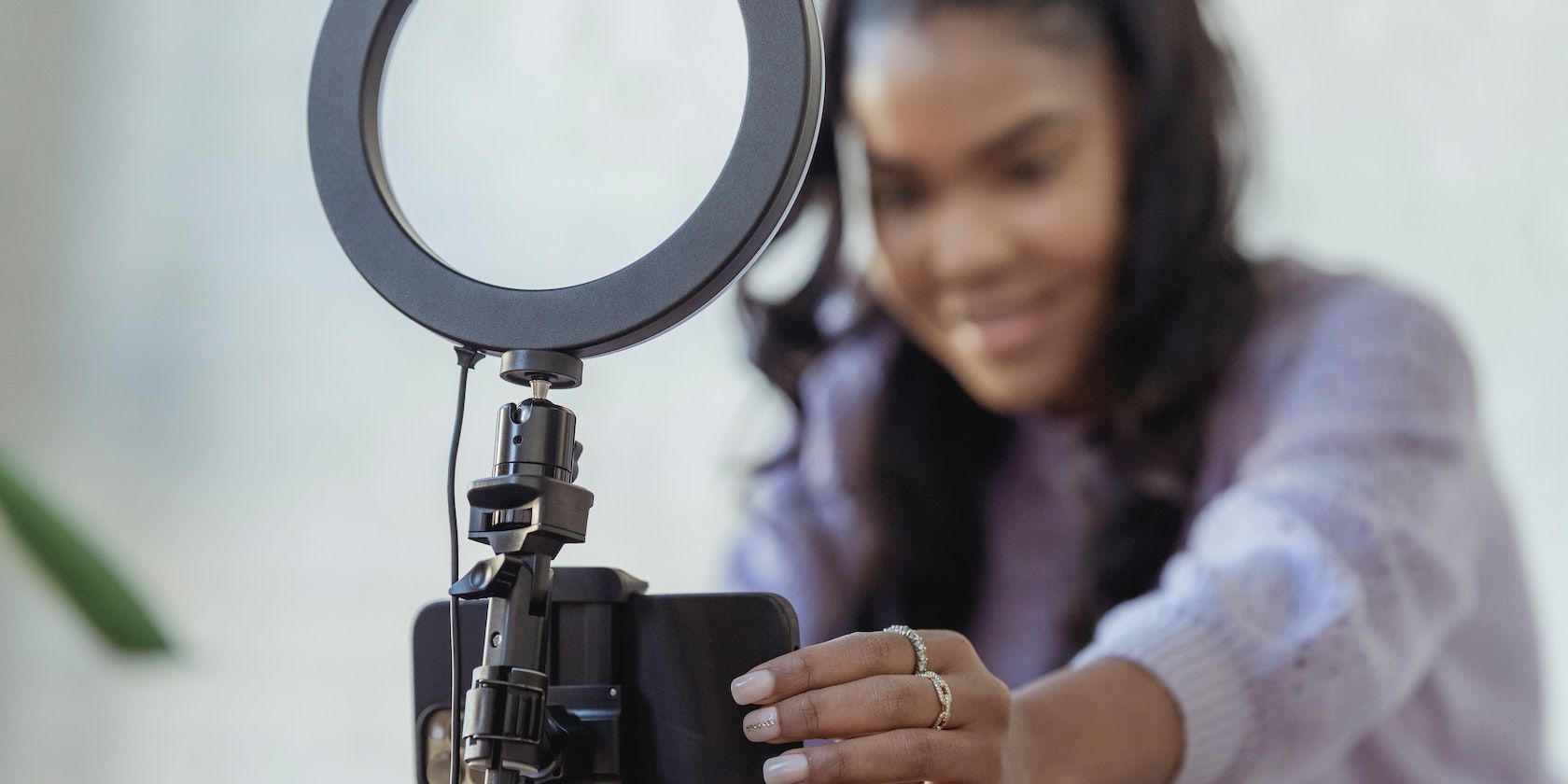 /pl/images/a-woman-adjusting-her-phone-on-a-ring-light-and-tripod-stand.JPG