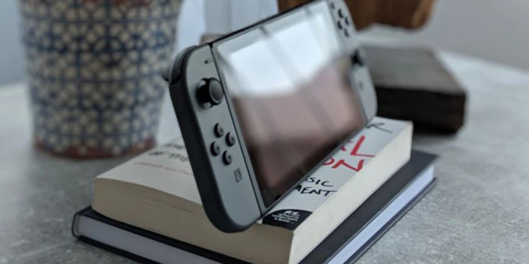 /pt/images/a-nintendo-switch-on-a-stack-of-books.jpg