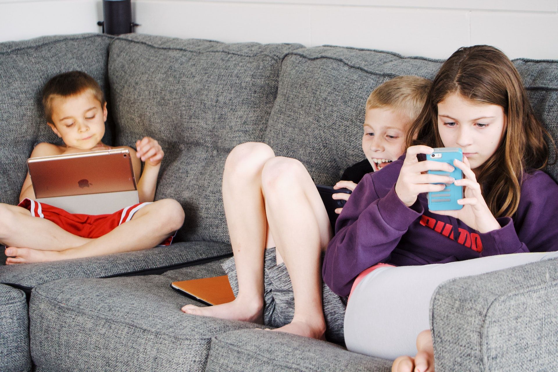 /pt/images/children-lying-on-sofa-and-using-gadgets.jpg