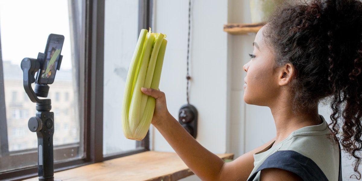 /pt/images/girl-holding-up-celery-on-camera.jpg