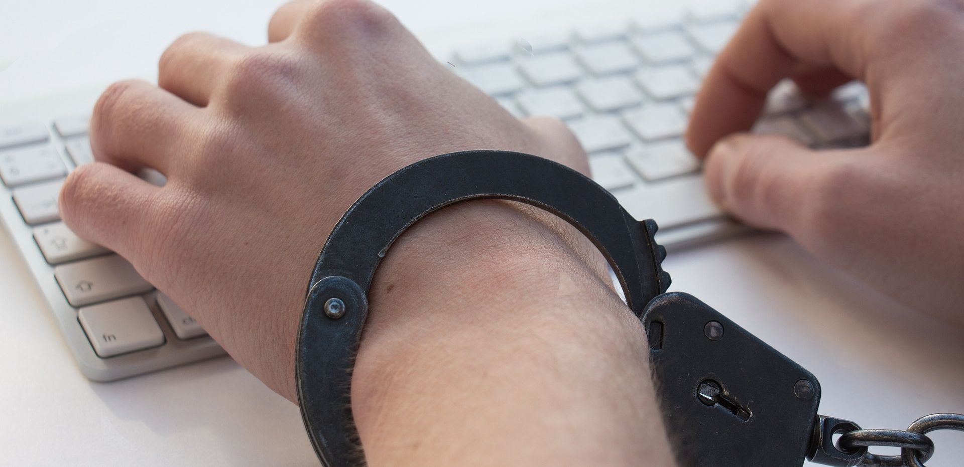 /pt/images/handcuffed-hands-typing-on-a-keyboard.jpg