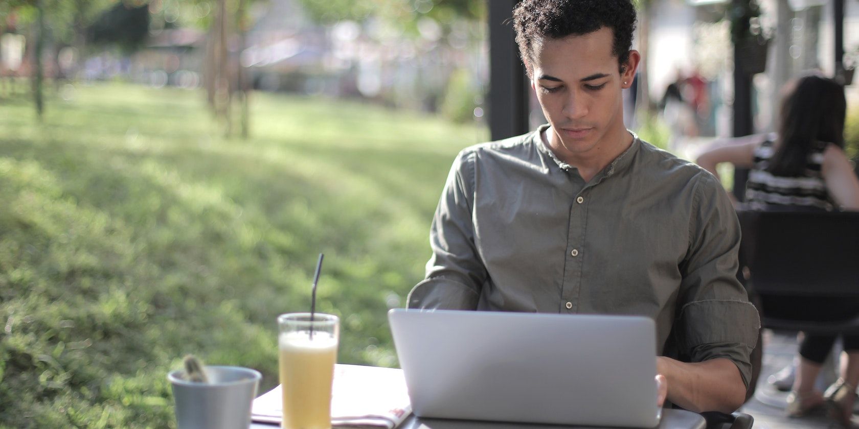 /pt/images/man-sitting-at-a-street-cafe-focused-on-laptop-screen.jpg