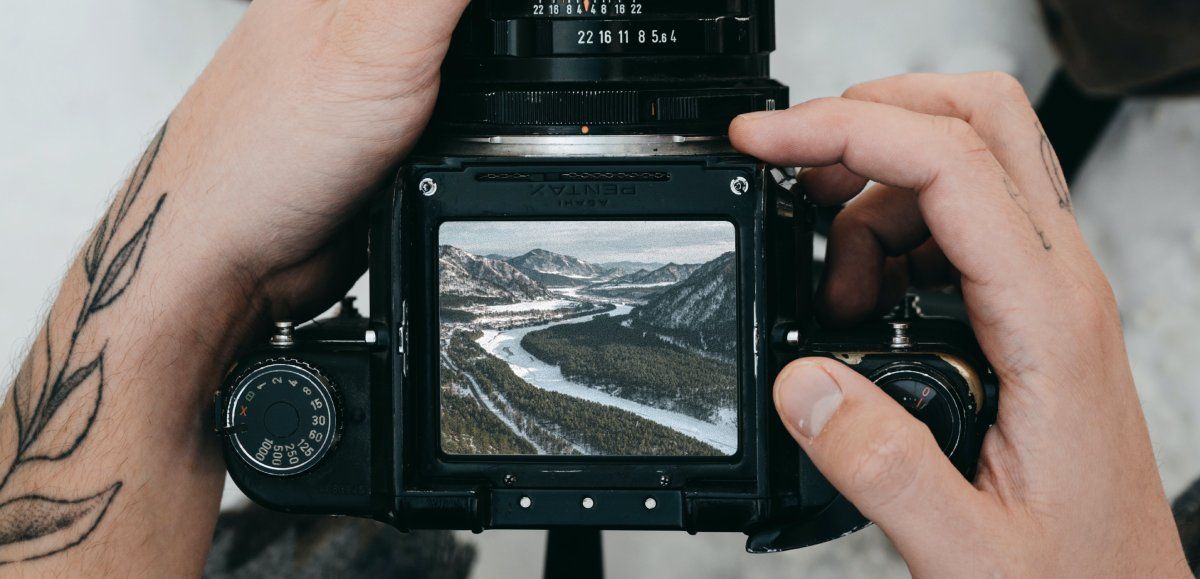 /pt/images/person-holding-camera-with-landscape-on-the-screen.jpg