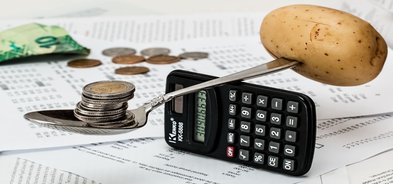/pt/images/spoon-with-coins-balancing-on-calculator-with-potato-on-the-other-end.jpg