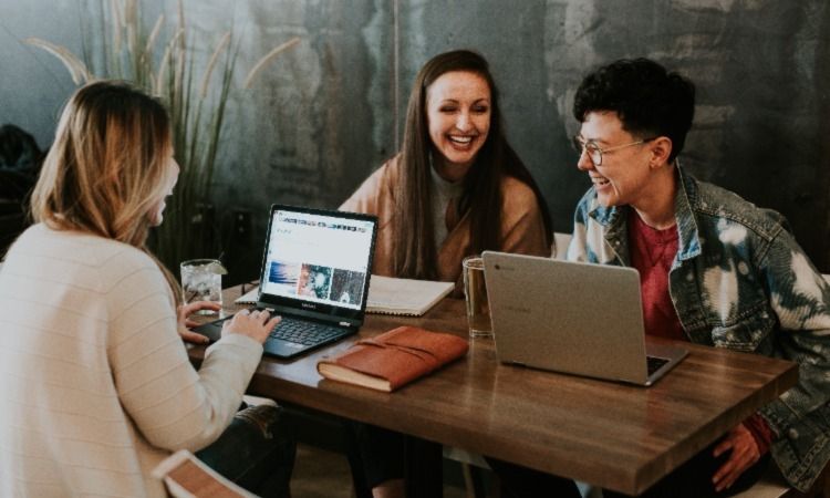 /pt/images/three-people-at-work-sitting-together-smiling.jpg
