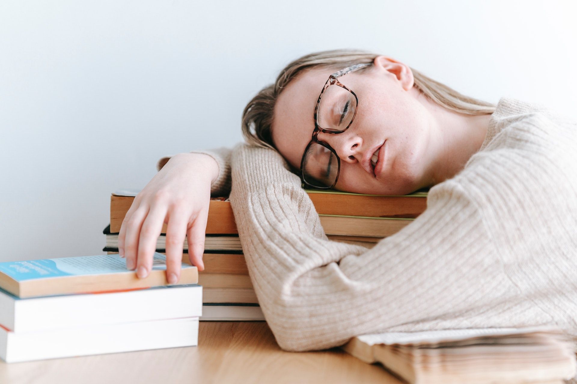 /pt/images/tired-female-student-sleeping-on-books-in-light-room-1.jpg