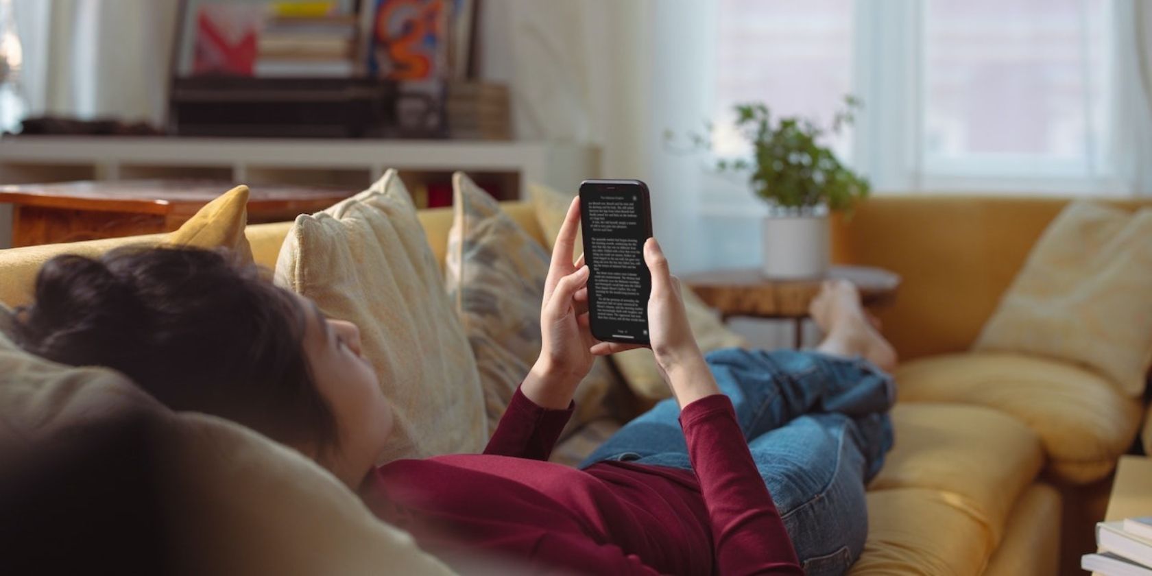 /sv/images/a-girl-lying-on-the-couch-reading-a-book-on-her-iphone.jpg