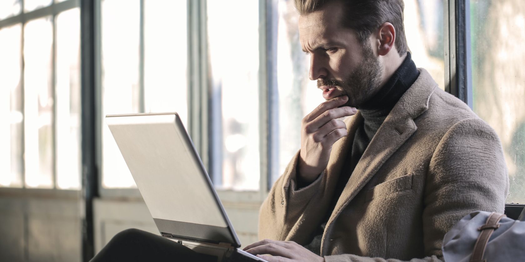 /sv/images/a-man-focusing-on-work-on-his-laptop-with-a-hand-on-his-chin.jpg