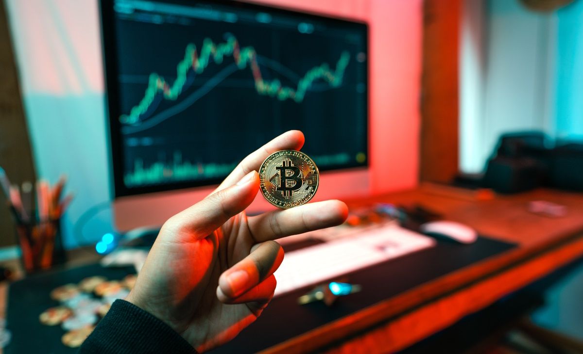 /sv/images/a-person-holding-a-bitcoin-in-front-of-a-computer.jpg