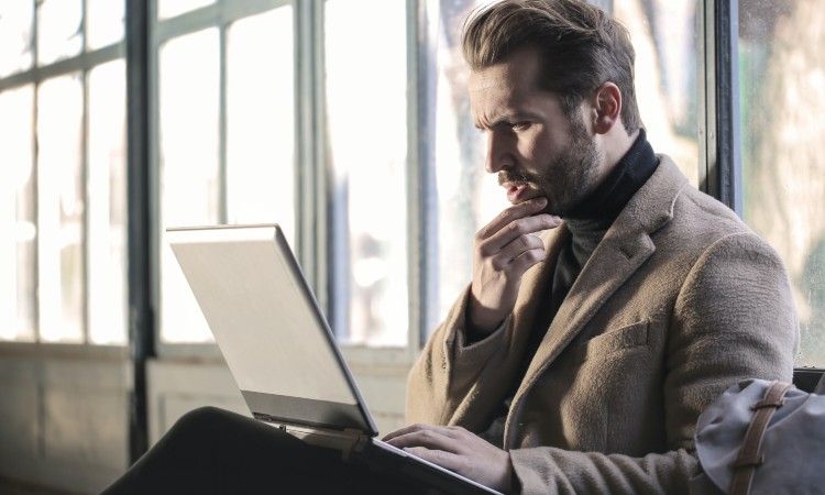/sv/images/concerned-man-holding-chin-looking-at-laptop.jpg