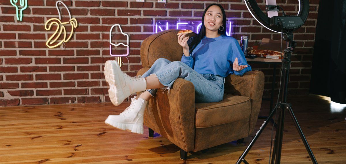 /sv/images/girl-sitting-in-chair-in-front-of-camera-eating-pizza.jpg
