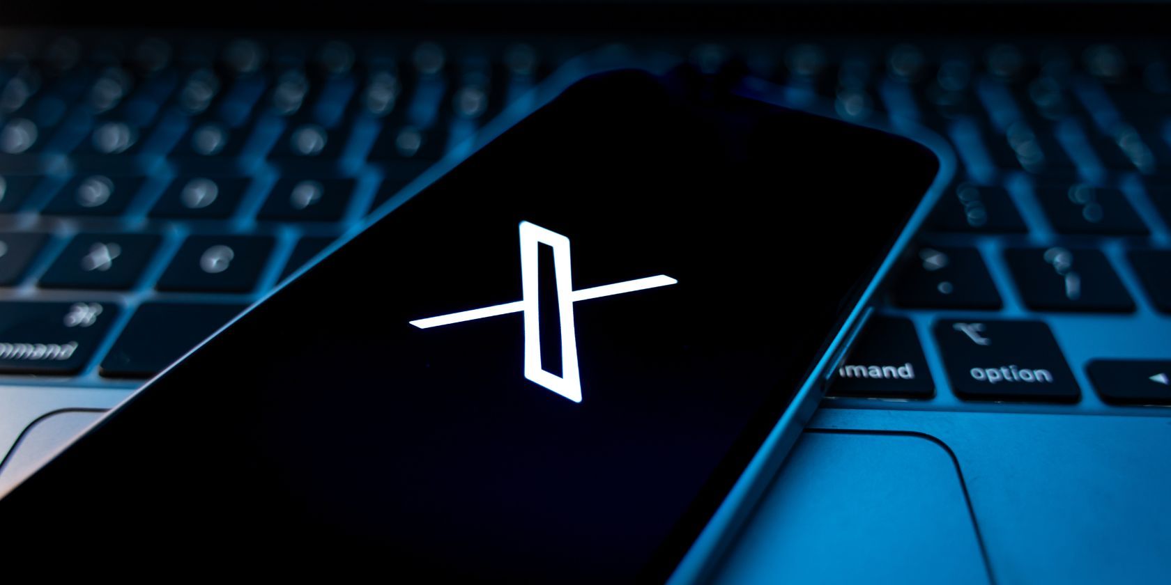 /sv/images/the-x-logo-on-a-smartphone-with-a-laptop-keyboard-in-the-background.jpg