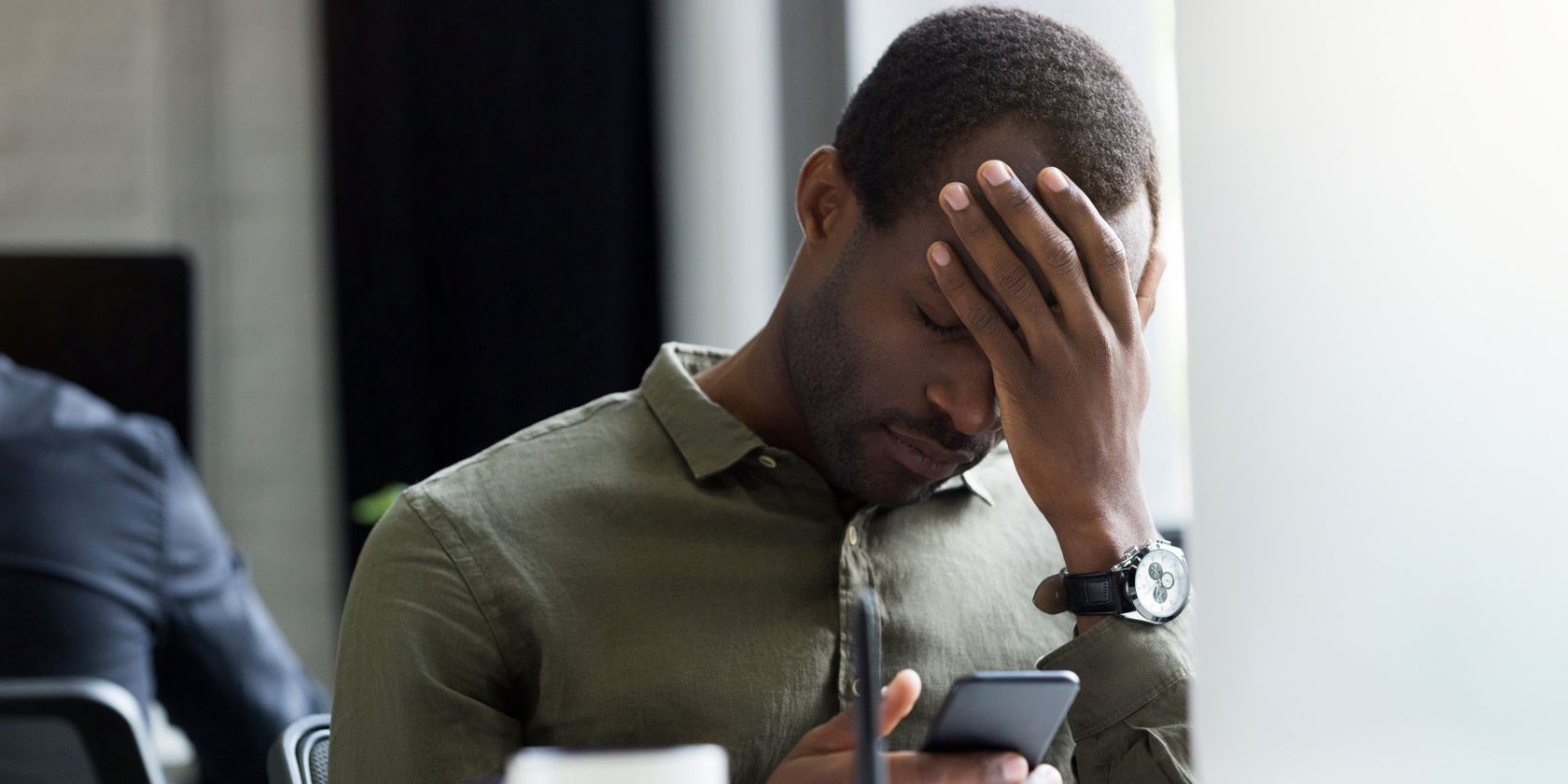 /th/images/upset-young-african-man-reading-message-his-mobile-phone.jpg