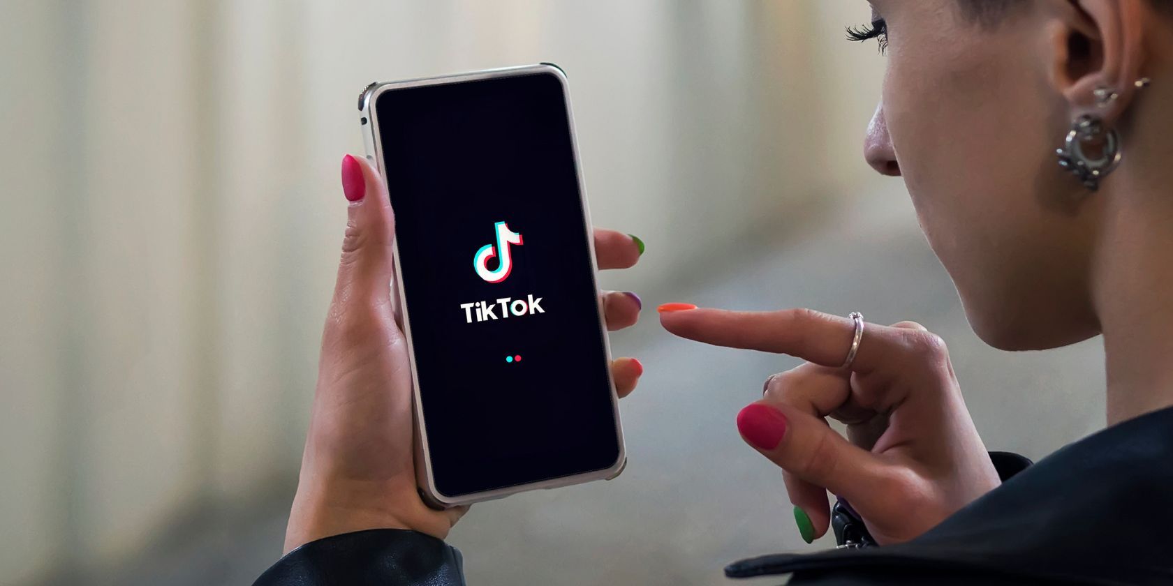 /th/images/women-holding-phone-with-tiktok-logo-on-the-screen.jpg